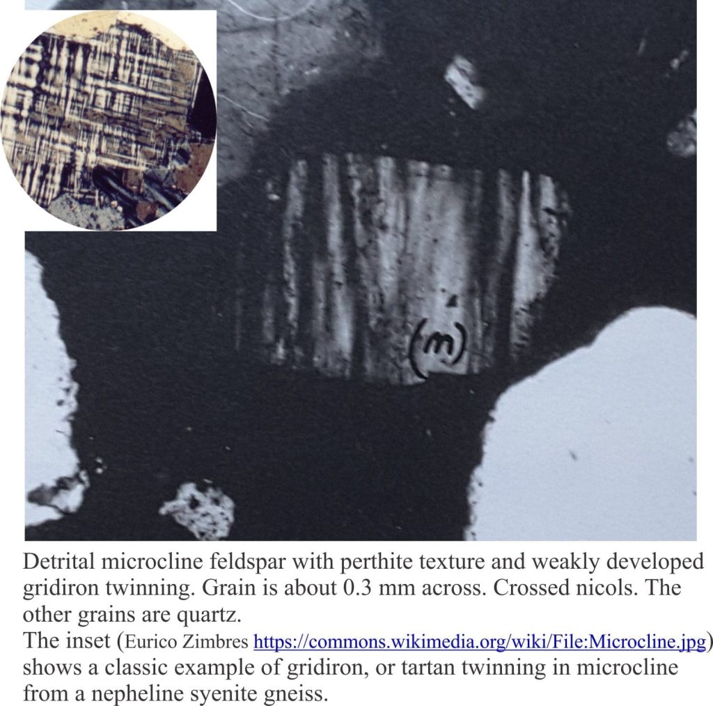 Microcline feldspar with perthite texture and weak gridiron twinning. Crossed nicols